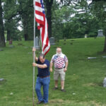 W.B. John Sheffield raises the flag while W.B. Wes Agar watches